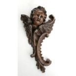 A carved wooden cherub wall bracket, 60cms high.