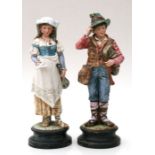 A pair of continental porcelain figures depicting a young boy holding a Dudelsack (German