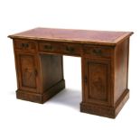 A late Victorian / Edwardian oak pedestal desk with leather inset top above an arrangement of