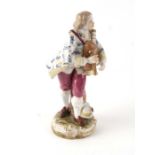 A 19th century Vienna porcelain figure depicting a young man playing the bagpipes, 18cms high.