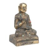 A gilt metal figure depicting a seated Buddha, seven character mark to the back, 13cms high.