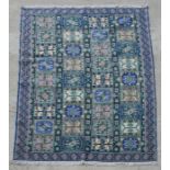 A Persian style carpet with repeating geometric patterns on a blue ground, 314 by 203cms.
