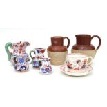 Two stoneware harvest jugs, 22cms high; together with four Ironstone Imari pattern jugs, the largest