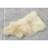 A sheepskin rug, approx 100cms long.