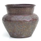 A patinated brass palm pot with embossed decoration, 20cms high.