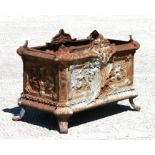 A French Louis XV style cast iron painted bombe form planter with scrolls, swags and floral