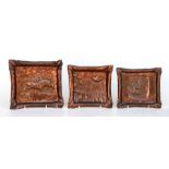 A set of three Arts & Crafts graduated rectangular copper trays with repousse decoration, the