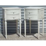 A pair of Louis XVI style white painted bedside cabinets with two drawers above reeded tapering