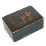 A black lacquer box with chinoiserie decoration containing letter tiles and a glass frog.