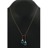 A 9ct gold necklace with two pale blue pear shaped crystal drops.