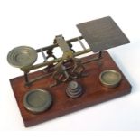 A set of Victorian brass postal scales and weights, 27cms wide.