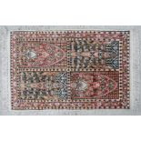 A modern silk rug with repeating floral designs on a multi coloured ground, 97 by 60cms.