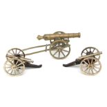 A pair of brass models of field cannons on wooden carriages, 21cms long; together with another