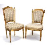 A pair of Louis XVI carved giltwood & gesso salon chairs with upholstered back and seats, on