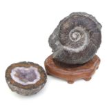 An ammonite fossil mounted on a hardwood stand, 13cms diameter; together with a crystal geode (2).