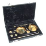 A cased set of brass balance scales.