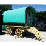 An early 20th century gypsy bowtop horses-drawn wagon with traditional painted decoration and fitted