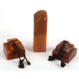 A Chinese figured soapstone stepped seal, another similar figured orange soapstone seal together a