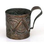An Islamic / Moorish tinned copper tankard with repeating repousse decoration, 10cms diameter.
