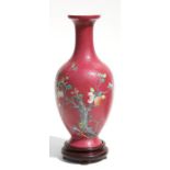 A Chinese baluster vase, the decoration of a peach tree with a bat and lingzhi, on a pink