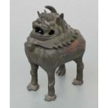 A Chinese bronze censer in the form of a temple lion with pierced hinged lid. 17cm high