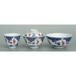 A Chinese blue, white and red cup and cover decorated with bats amongst stylised clouds, six