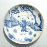 A Chinese blue & white shallow dish decorated with a figure standing beneath a peach tree, 20cms