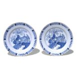 A pair of Delft blue & white plates with unusual landscape scenes depicting a tent beside a tree,