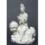 A Chinese blanc de chine group depicting Guanyin seated on a temple lion, 29cms high.