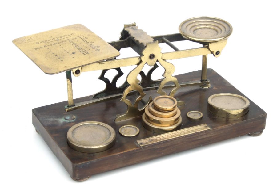 A Victorian S Morden & Co set of brass postal scales and weights on a walnut base, 27cms wide.