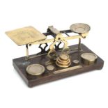 A Victorian S Morden & Co set of brass postal scales and weights on a walnut base, 27cms wide.