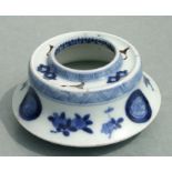 A Chinese blue & white brush washer decorated with flowers and roundels, 9cms diameter.