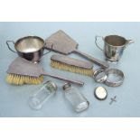 An Art Deco three-piece silver dressing table set; together with a silver bangle; a silver napkin