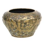 An Islamic brass palm pot decorated in relief with Islamic script, 26cms diameter.