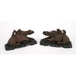 A pair of Chinese hardwood carved groups depicting figures riding oxen, on associated pierced