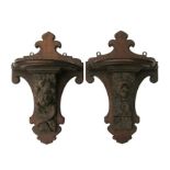 A pair of oak wall brackets, each with an early oak carved corbel, one depicting a lion, the other a