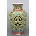 A Chinese famille rose reticulated vase with internal cylinder, decorated with scrolling flowers