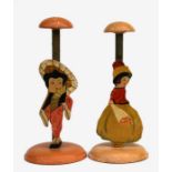 A pair of early 20th century painted wooden hat stands depicting two girls, 24cms high (2).