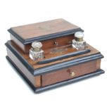 An Edwardian desk top stationery box, the lift-up top enclosing a fitted interior, with two glass