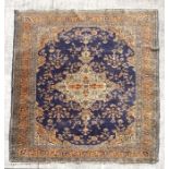 A Turkish hand knotted woollen rug, the central gul within stylised floral borders, on a beige