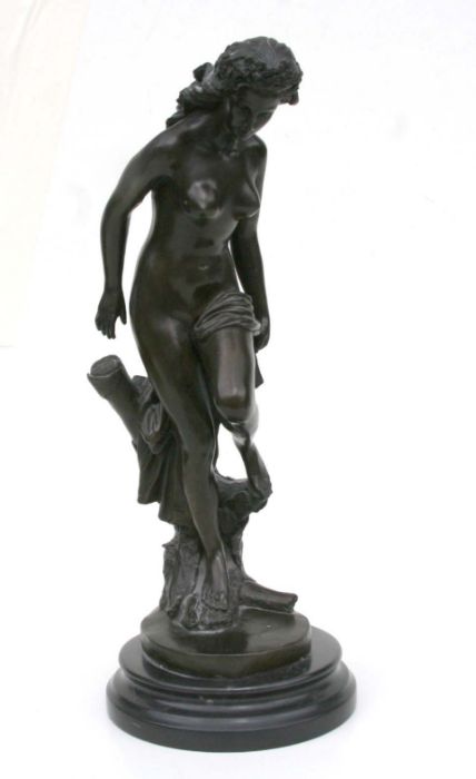 A bronze study of a naked female stood by a tree stump, mounted on a marble plinth, 42cms high.