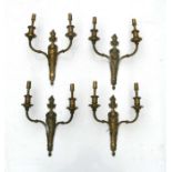 A set of four gilt bronze / brass twin-arm wall lights, each 31cms high (4).