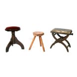 An elm three-legged stool; together with two piano stools (3).