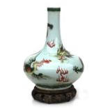 A large Chinese bottle vase decorated with a dragon and phoenix chasing a flaming pearl on a celadon