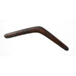 An early 20th century Aboriginal boomerang with carved decoration, 61cms wide.