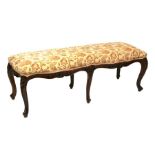 A 19th century style mahogany window seat or stool, on six carved cabriole legs, 139cms wide.