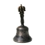 A Tibetan silver coloured and silver gilt coloured hand bell, 18cms high.