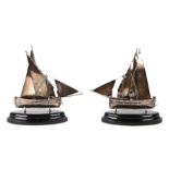 A pair of Maltese silver boats with twin sails and rudders, mounted on ebonised plinths, 16cms