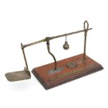 An unusual set of Victorian De Grove & Co. brass postal scales on a mahogany base, 41cms wide.