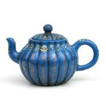 A Chinese Yixing pottery teapot painted with flowers and gilt symbols on a blue ground, impressed